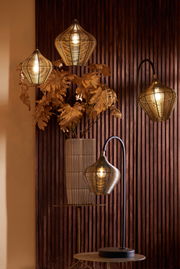 Vier Hängeleuchten in verschiedenen Höhen vor einer Holzvertäfelung, mit warmem Licht und dekorativen Blättern im Hintergrund. Perspektive von vorne.