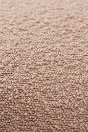 Nahaufnahme einer strukturierten, beigen Stoffoberfläche, die für eine Zierkissenhülle verwendet wird.