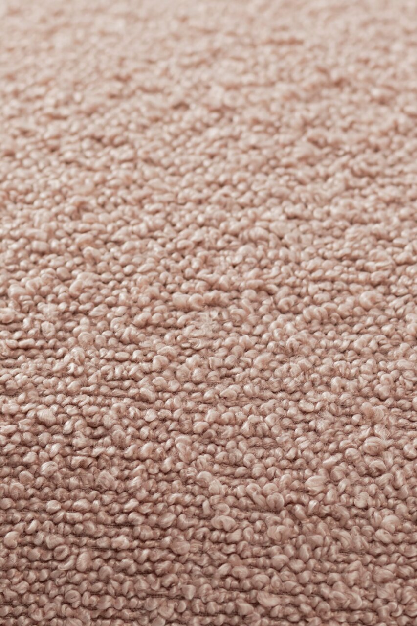 Nahaufnahme einer strukturierten, beigen Stoffoberfläche, die für eine Zierkissenhülle verwendet wird.