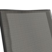 Nahaufnahme der Rückenlehne eines Stapelstuhls mit grauem Fischgrätenmuster, seitliche Perspektive