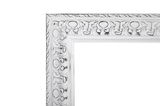 Detailansicht eines weißen, verzierten Spiegelrahmens mit antikem Finish.