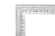 Detailansicht eines weißen, verzierten Spiegelrahmens mit antikem Finish.