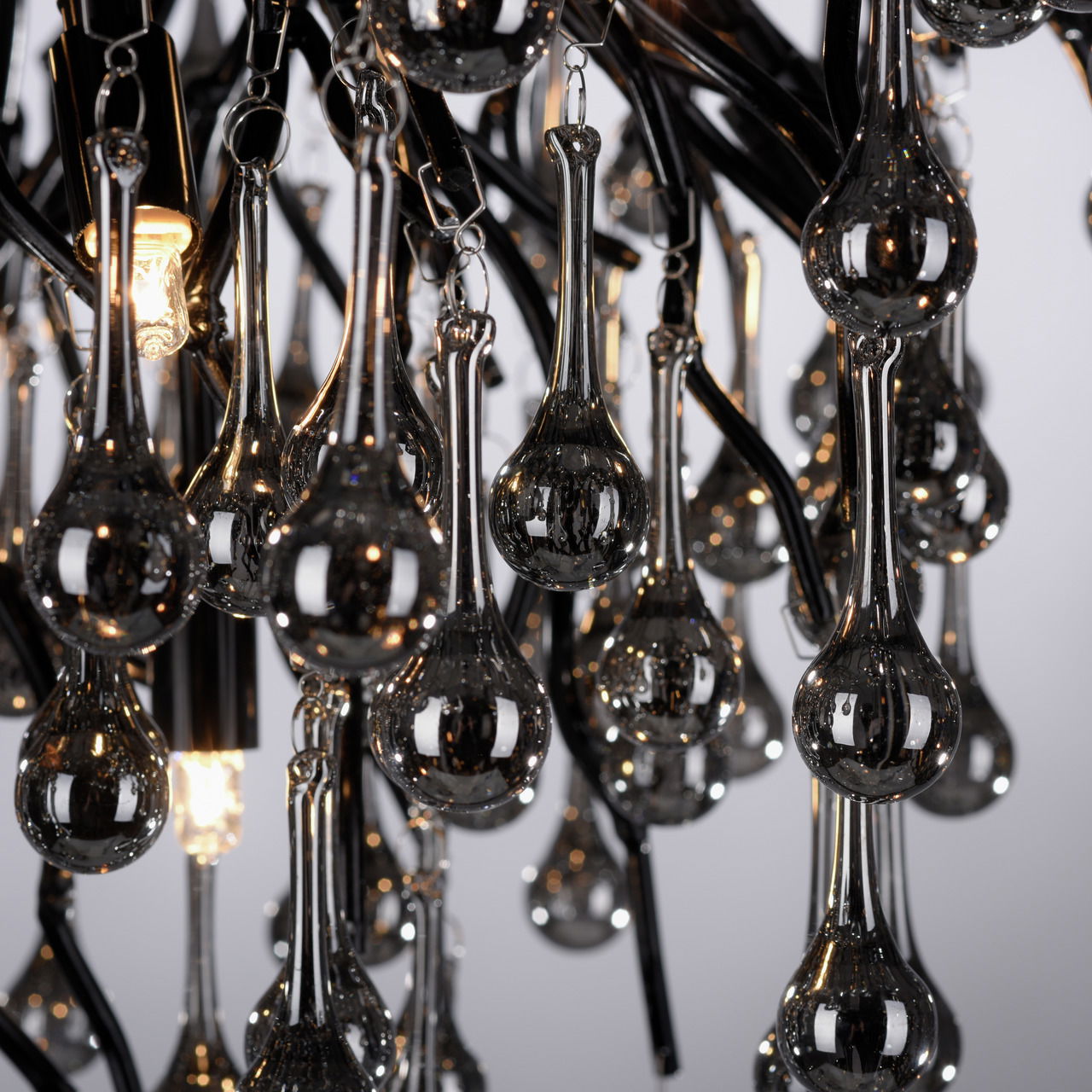 Nahaufnahme der Deckenleuchte ICICLE mit hängenden, tropfenförmigen Glaselementen und leuchtenden Lichtern.