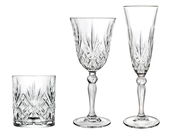 Drei Kristallgläser in Frontalansicht: ein Whiskyglas, ein Weinglas und ein Sektglas, alle mit elegantem Schliffmuster.