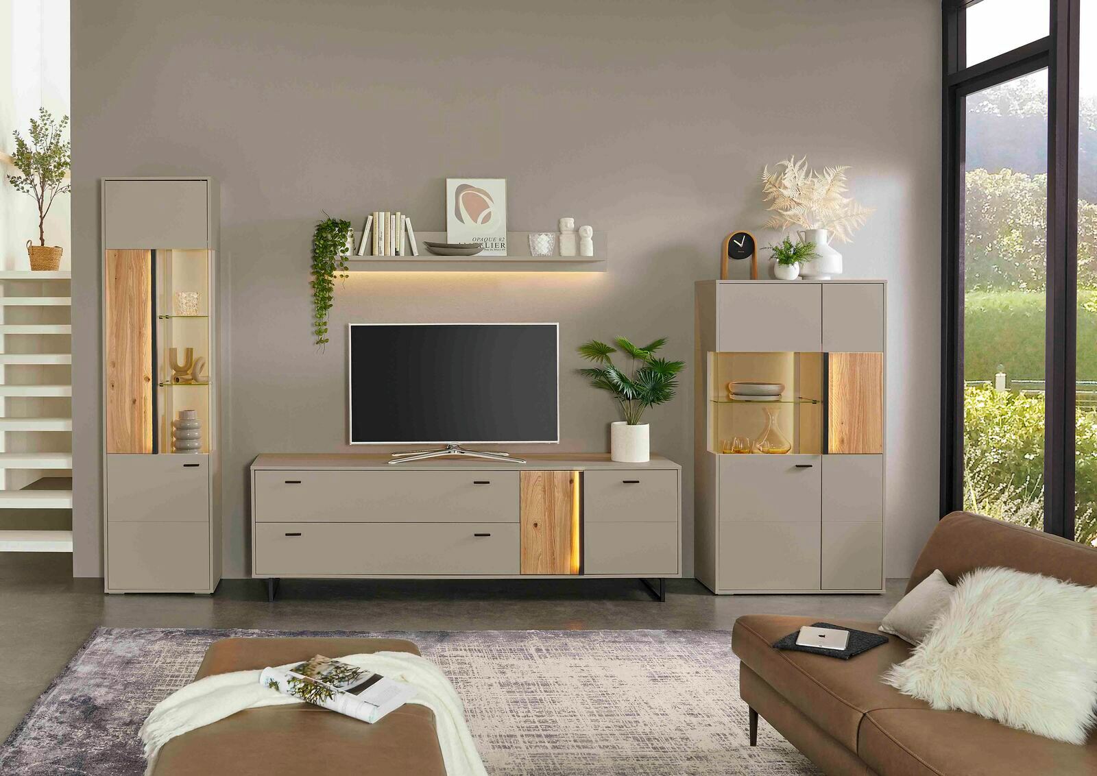 Modernes TV-Lowboard in einem stilvollen Wohnzimmer, frontal betrachtet, mit dekorativen Elementen und einem Fernseher darauf.