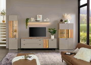 Een modern tv-lowboard in een stijlvolle woonkamer, gezien vanaf de voorkant, met decoratieve elementen en een tv erop.