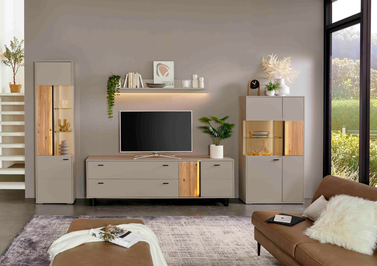 Een modern tv-lowboard in een stijlvolle woonkamer, gezien vanaf de voorkant, met decoratieve elementen en een tv erop.
