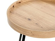 Detailaufnahme eines runden Beistelltischs mit Holzplatte und erhöhtem Rand auf schwarzen Metallbeinen, Ansicht schräg von oben