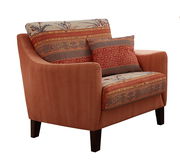 Gemütlicher Sessel mit gemusterten Kissen und Polsterung in warmen Erdtönen, seitliche Perspektive