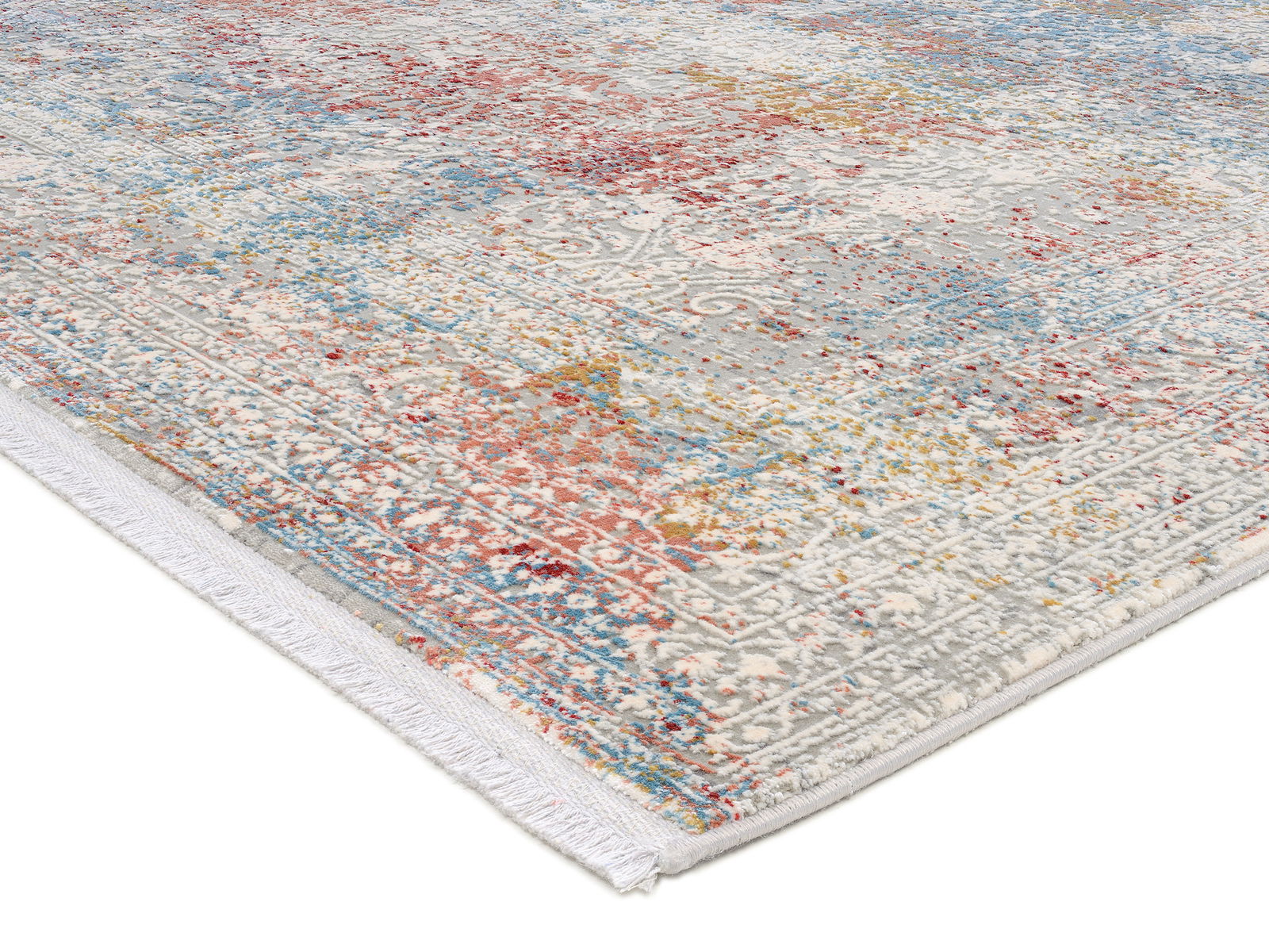 Designer Teppich mit buntem, abstraktem Muster in Rot-, Blau- und Gelbtönen, perspektivisch von der Seite fotografiert.