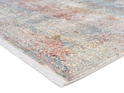 Designer Teppich mit buntem, abstraktem Muster in Rot-, Blau- und Gelbtönen, perspektivisch von der Seite fotografiert.