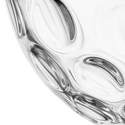 Close-up van een doorzichtige glazen schaal met een optisch patroon, gezien vanaf de zijkant