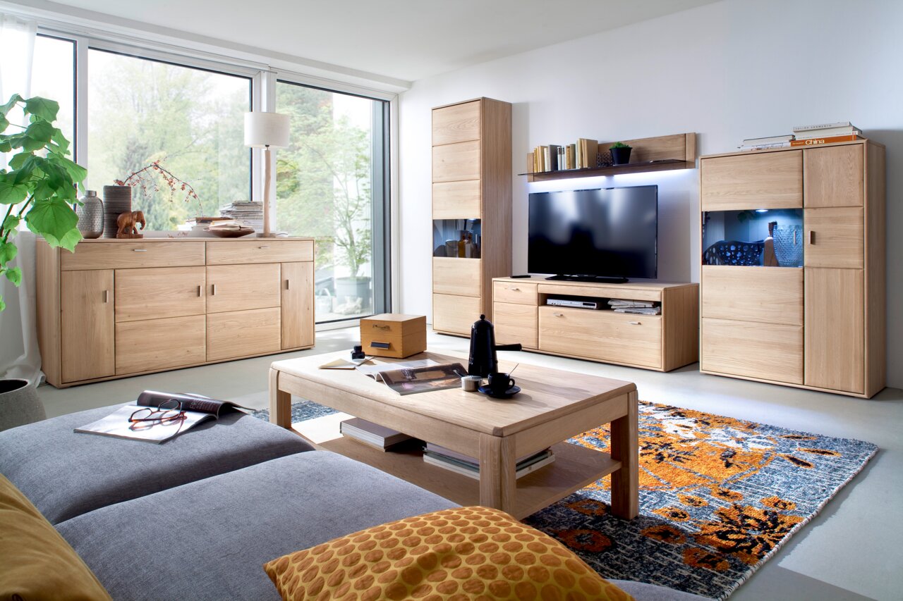 Cantus Wandboard TARRAGONA Wohnzimmer mit moderner Holzmöbelkombination, bestehend aus Sideboard, Highboard, TV-Board und Wandregal, in heller, freundlicher Atmosphäre. Perspektive von der Couch aus.