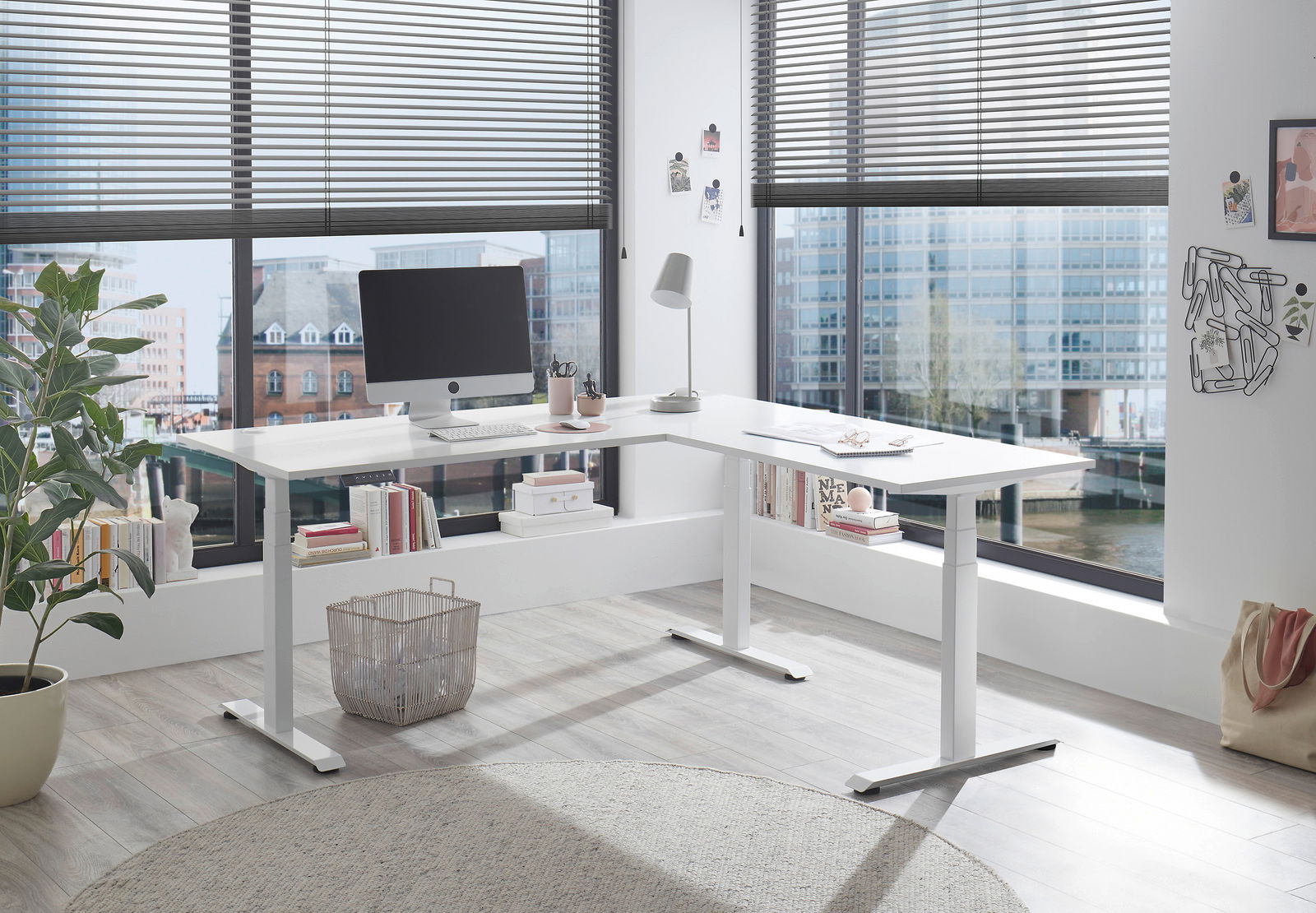 E-Serie E-Eckschreibtisch E-CORNER Moderner weißer E-Eckschreibtisch in einem hellen Büro mit großen Fenstern, seitliche Perspektive.