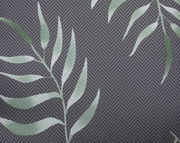 Nahaufnahme einer Mittellehnerauflage mit grünem Blattmuster auf grauem Hintergrund in Fischgrätmuster.