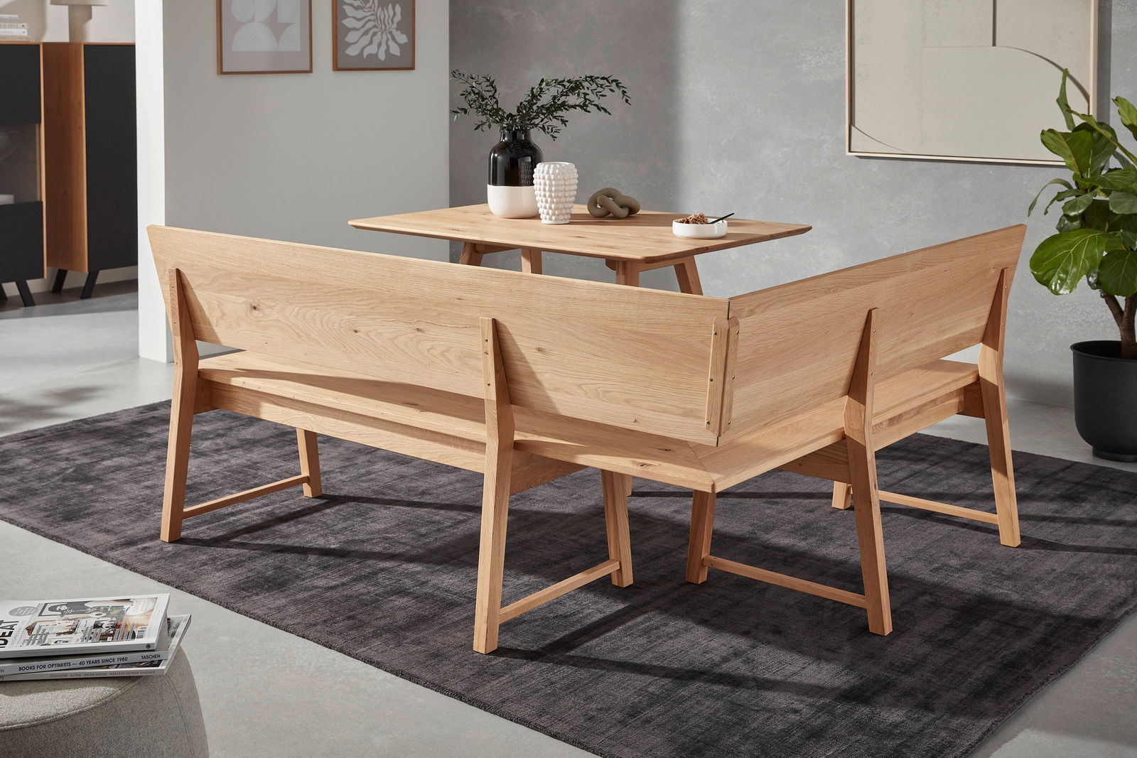 Rückansicht einer Eckbank aus Holz in einem modernen Wohnzimmer, mit einem Tisch und Dekorationen.