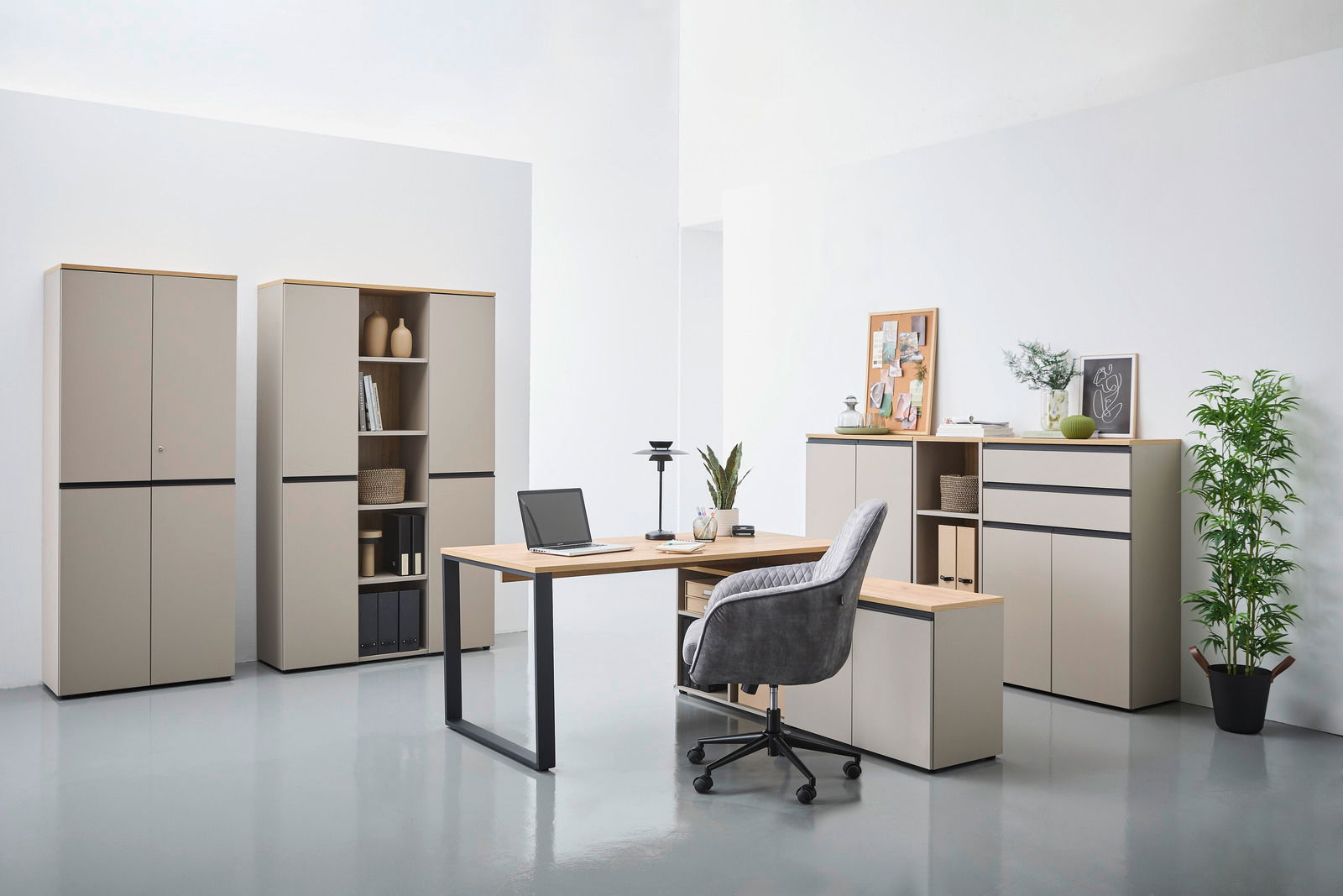 Moderne Büromöbel in einem hellen Raum, bestehend aus einem Winkelschreibtisch, mehreren Aktenschränken und einem Rollcontainer. Perspektive von vorne.