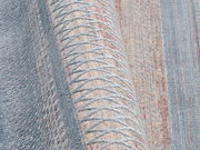 Nahaufnahme eines Designer-Teppichs mit geometrischem Muster in Blau- und Beigetönen, seitliche Perspektive