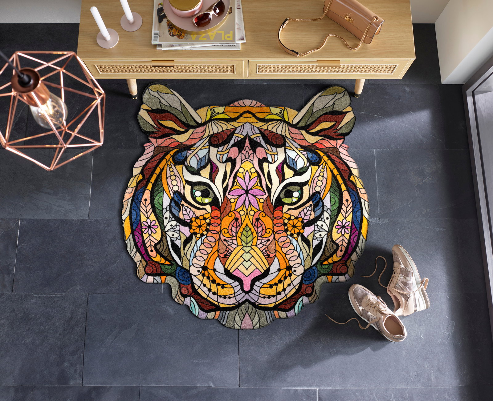 Zurbrüggen Fußmatte WILDERNESS Bunte, kunstvolle Tigerkopf-Matte auf dunklem Boden, von oben betrachtet, mit dekorativen Elementen und Schuhen daneben.