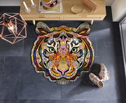 Bunte, kunstvolle Tigerkopf-Matte auf dunklem Boden, von oben betrachtet, mit dekorativen Elementen und Schuhen daneben.