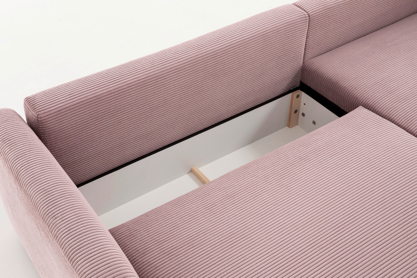 Nahaufnahme einer rosa gepolsterten Rundecke mit Stauraum, von oben betrachtet.