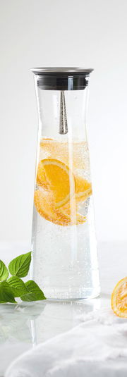 Karaffe mit 1,1 l Fassungsvermögen, gefüllt mit sprudelndem Wasser und Orangenscheiben, aus der Seitenperspektive fotografiert.