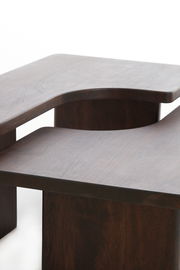 Moderner Couchtisch aus dunklem Holz mit geschwungenem Design, seitliche Perspektive