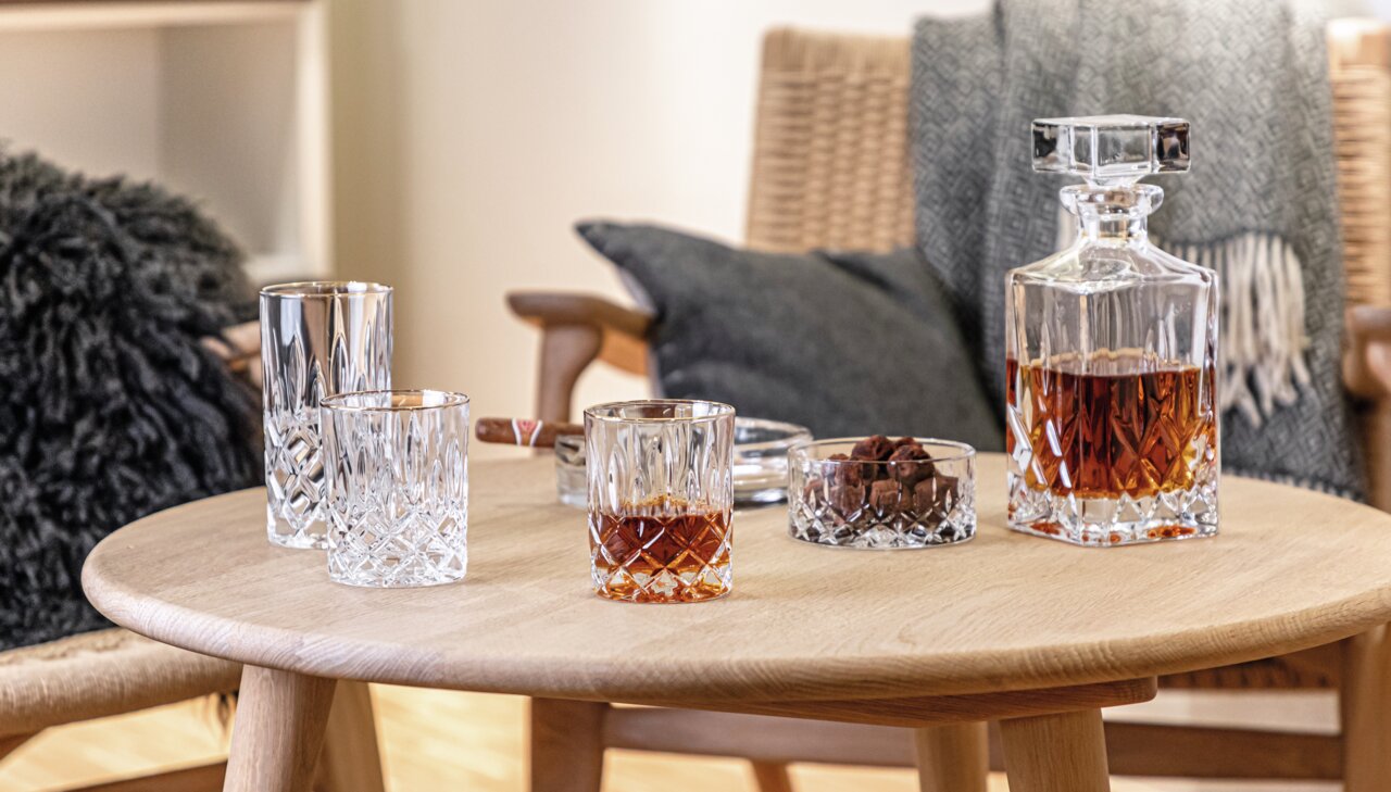 Nachtmann Whiskyglas NOBLESSE Whiskybecher Noblesse 295ml auf einem Tisch in gemütlicher Wohnzimmeratmosphäre, seitliche Perspektive