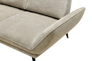 Nahaufnahme eines beigen Longchairs mit weichem Stoffbezug und schwarzen Beinen, seitliche Perspektive.