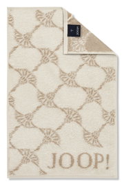 Beiges Gästetuch mit geometrischem Muster und dem Schriftzug 'JOOP!' in der unteren rechten Ecke, von oben betrachtet.
