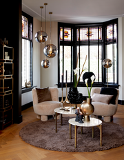 Moderne Hängeleuchte MEDINA mit drei kugelförmigen Lampen in einem stilvollen Wohnzimmer, seitliche Perspektive.