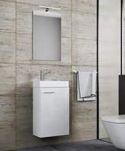 Modernes Badezimmer-Set mit wandhängendem weißem Waschtischunterschrank, Aufsatzwaschbecken, Chromarmatur und Spiegel mit LED-Leuchte vor beiger Steinfliesenwand, Frontansicht leicht seitlich von links