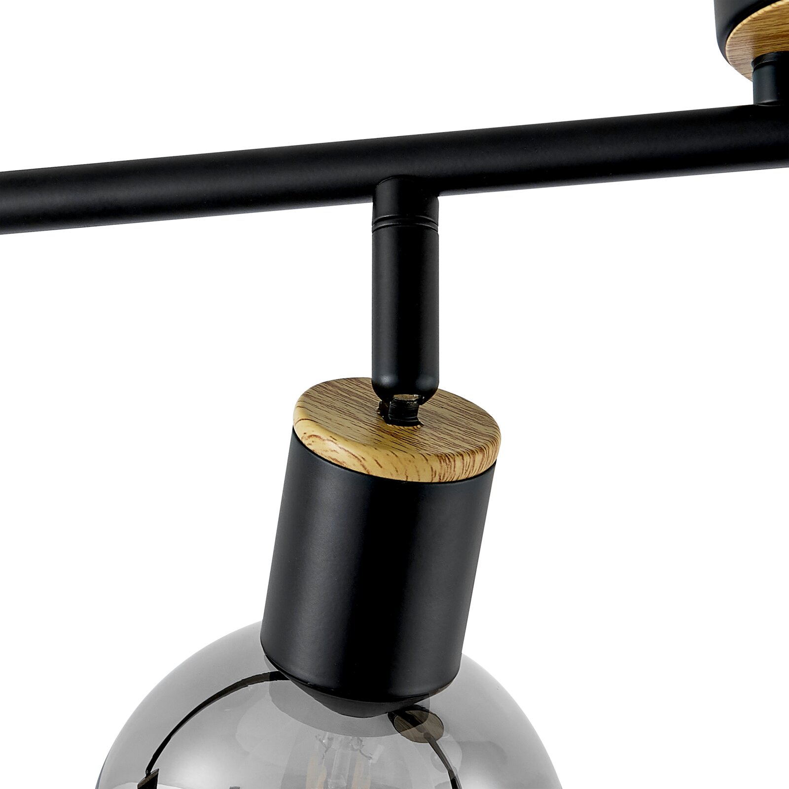 Detailaufnahme einer modernen Deckenleuchte mit schwarzem Metallarm, zylindrischem Lampenkopf mit Holzabschluss und Rauchglas-Kugel, Perspektive leicht von unten/seitlich