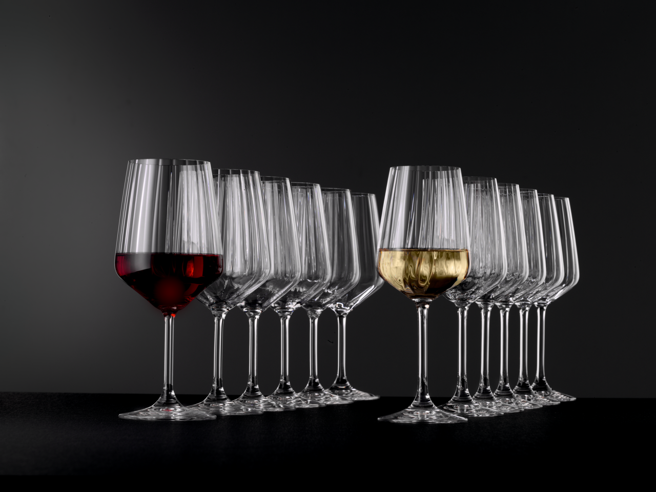 Stielglas Set mit 12 Gläsern, gefüllt mit Rot- und Weißwein, seitliche Perspektive