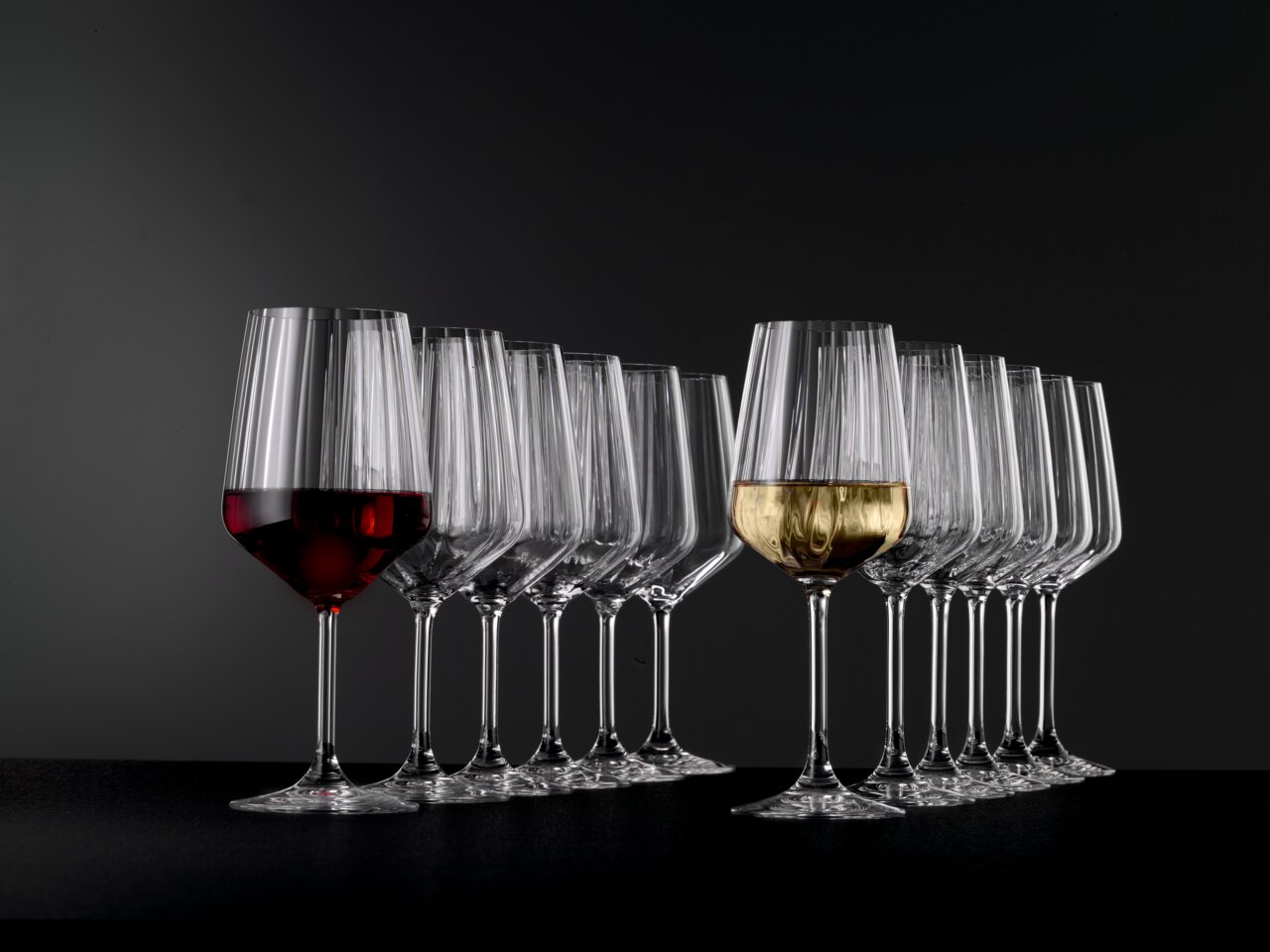 Stielglas Set mit 12 Gläsern, gefüllt mit Rot- und Weißwein, seitliche Perspektive