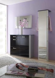 Moderner, schmaler Standspiegel in einem eleganten Raum mit lila Wand und schwarzem Schrank, seitliche Perspektive.