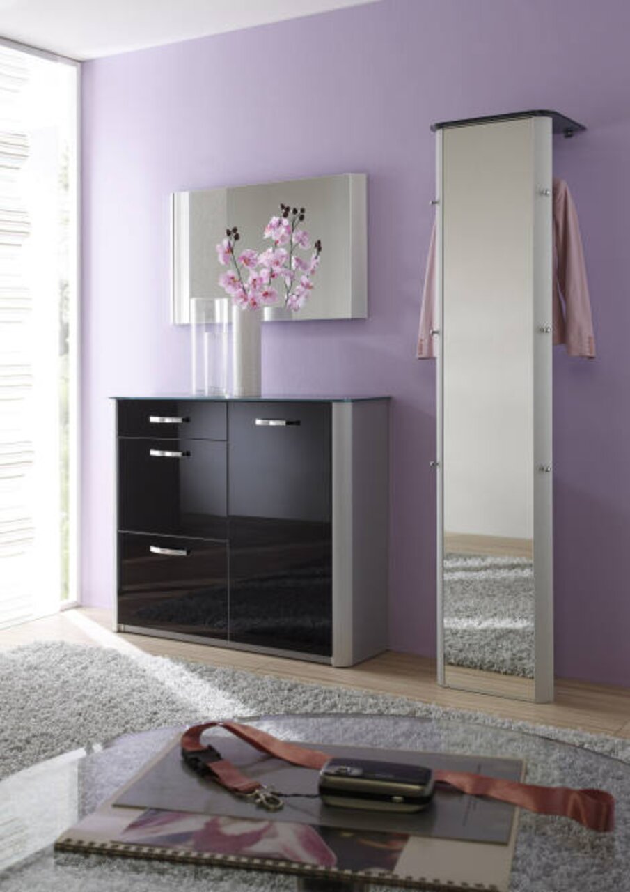 Moderner, schmaler Standspiegel in einem eleganten Raum mit lila Wand und schwarzem Schrank, seitliche Perspektive.