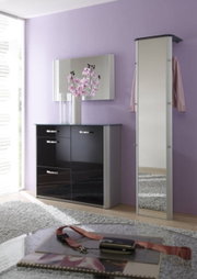 Moderner, schmaler Standspiegel in einem eleganten Raum mit lila Wand und schwarzem Schrank, seitliche Perspektive.