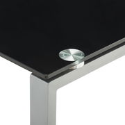 Nahaufnahme eines modernen Schreibtischs mit schwarzer Glasplatte und silbernem Metallrahmen, Perspektive von oben auf die Ecke.