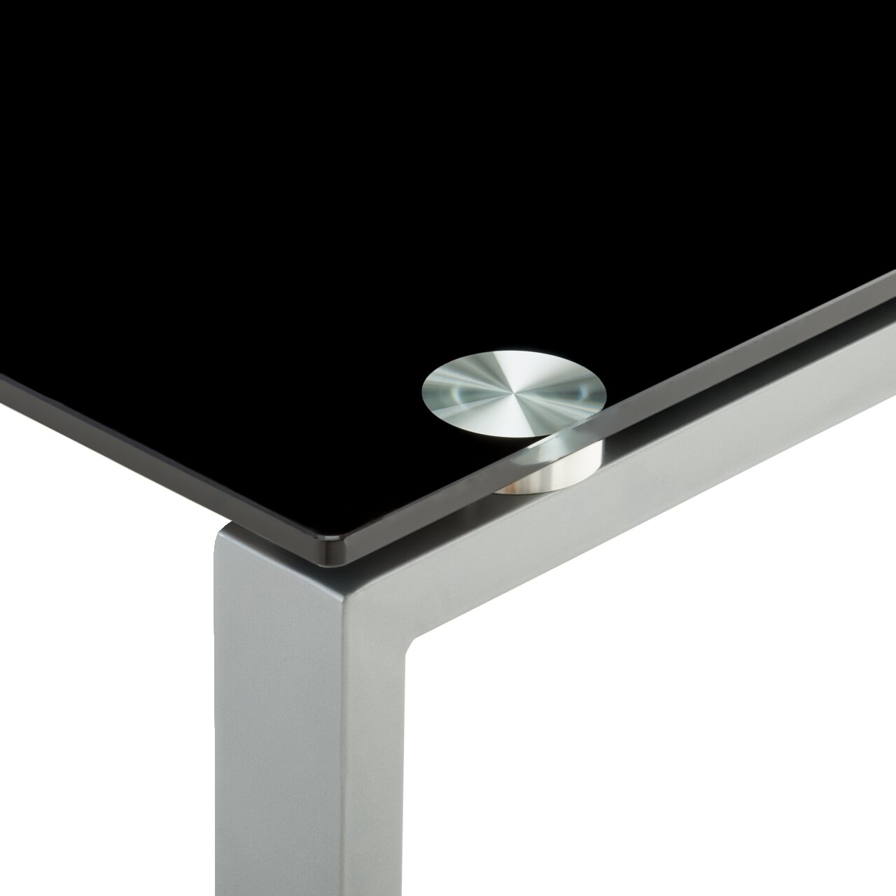 Close-up van een modern bureau met een zwart glazen blad en een zilverkleurig metalen frame, gezien van bovenaf op de hoek.