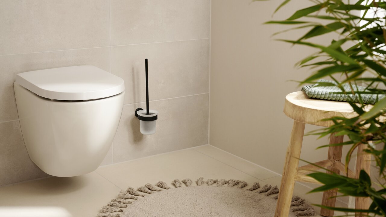 Tesa WC-Bürstenhalter MOON BLACK Schwarzer WC-Bürstenhalter der Marke tesa MOON BLACK, an der Wand neben einer Toilette montiert, aus seitlicher Perspektive fotografiert.