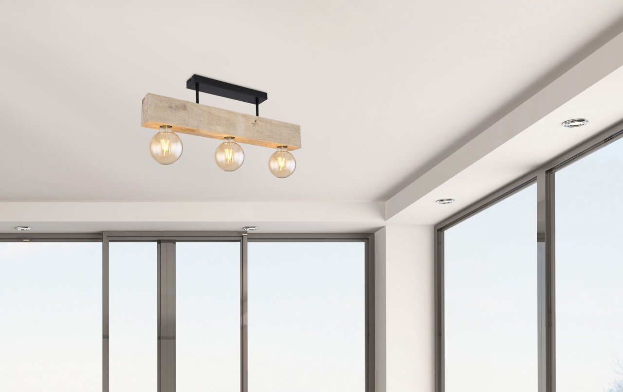 Moderne Deckenleuchte mit drei sichtbaren Glühbirnen, montiert an einem Holzbalken, aus der Perspektive von unten betrachtet.