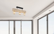 Moderne Deckenleuchte mit drei sichtbaren Glühbirnen, montiert an einem Holzbalken, aus der Perspektive von unten betrachtet.