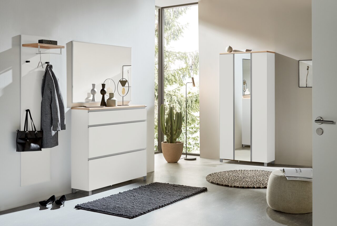 Dieter Knoll Garderoben-Set 4-tlg. SORRENT Moderner Eingangsbereich mit Garderobenmöbeln in Weiß, bestehend aus Schuhschrank, Garderobenpaneel und Spiegel, mit Blick auf eine grüne Außenlandschaft.