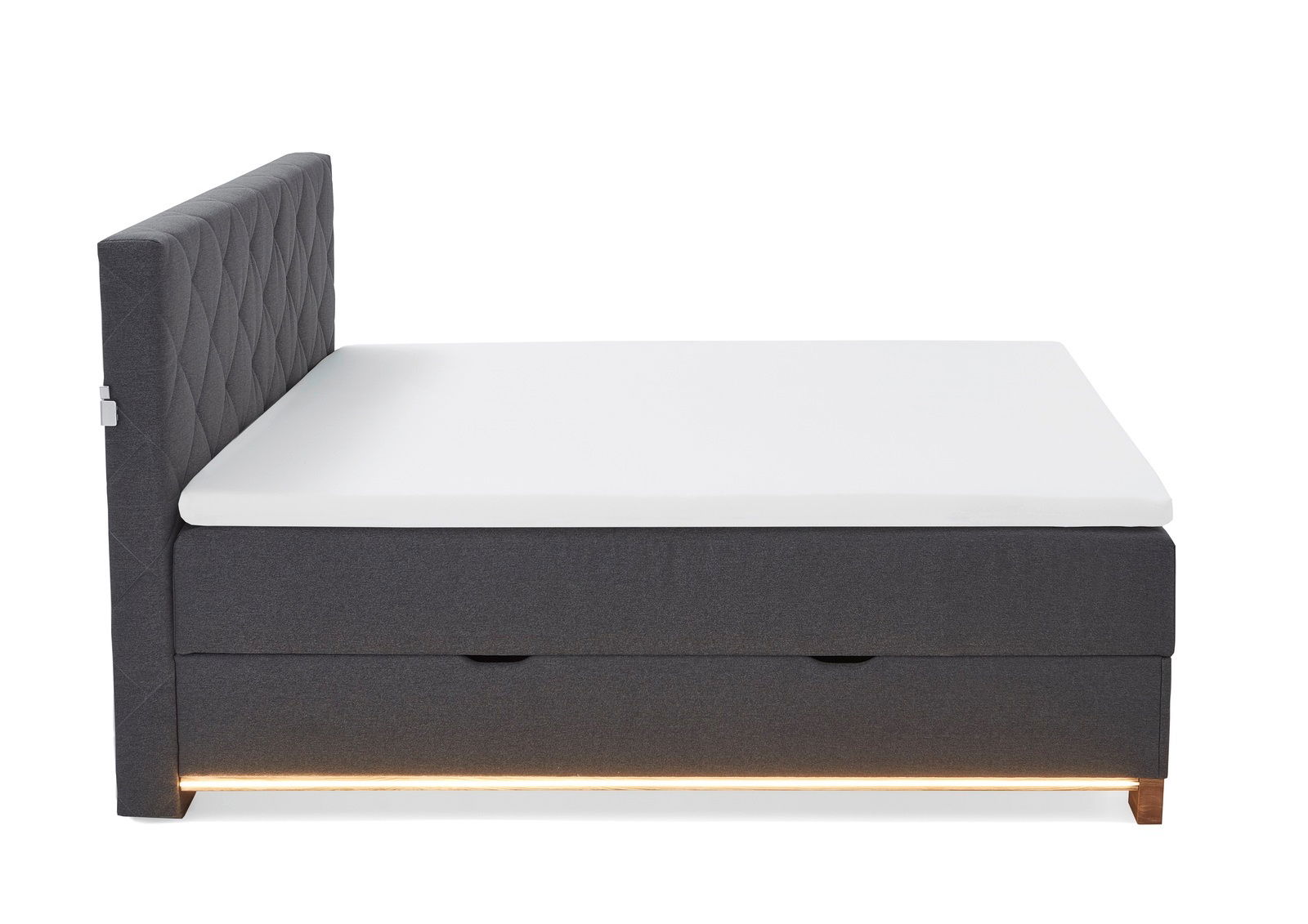 Seitenansicht eines grauen Boxspringbetts mit weißer Matratze und beleuchtetem Sockel.