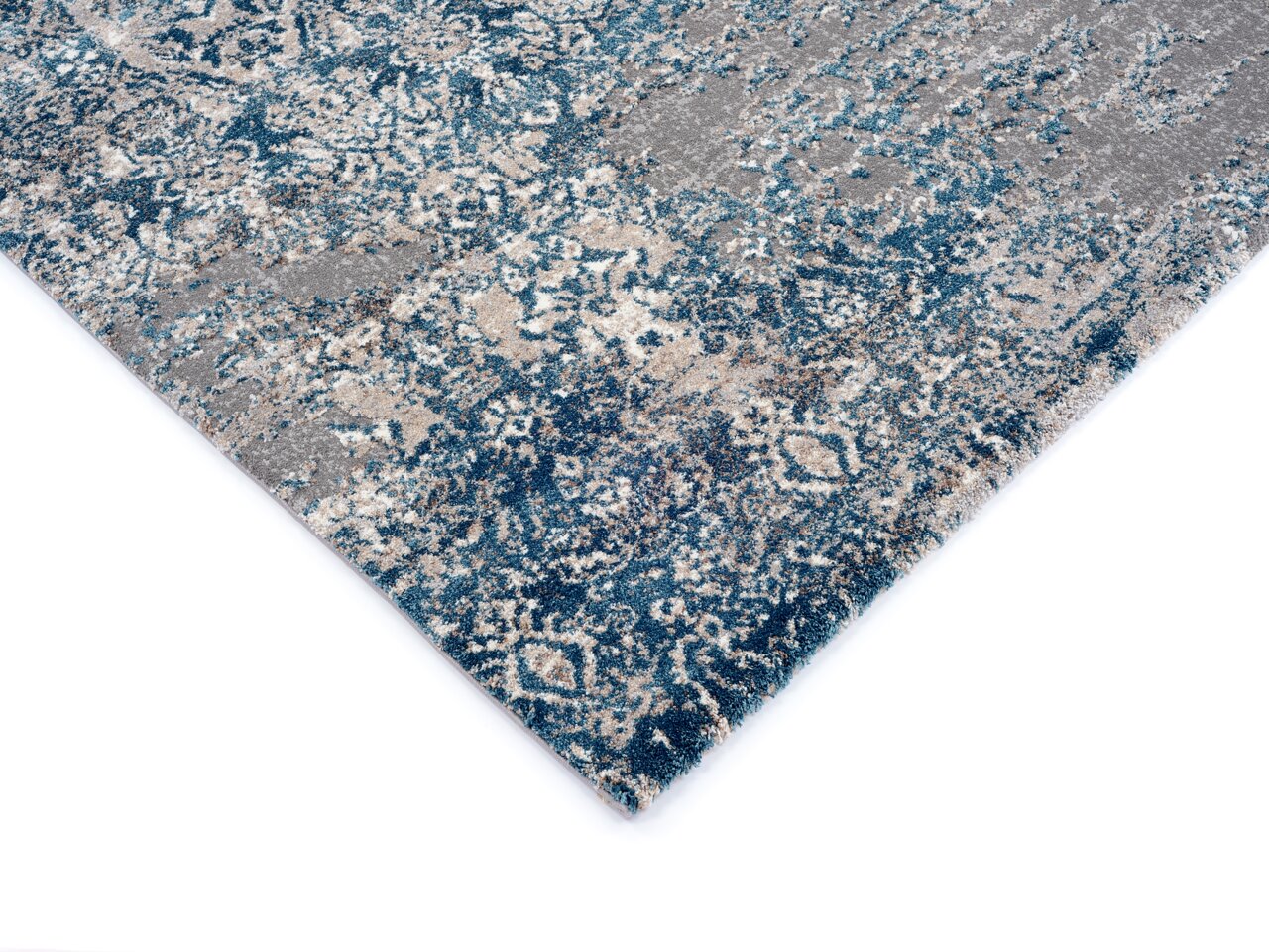 Designer Teppich mit blau-grauem Muster, perspektivisch von der Ecke aufgenommen