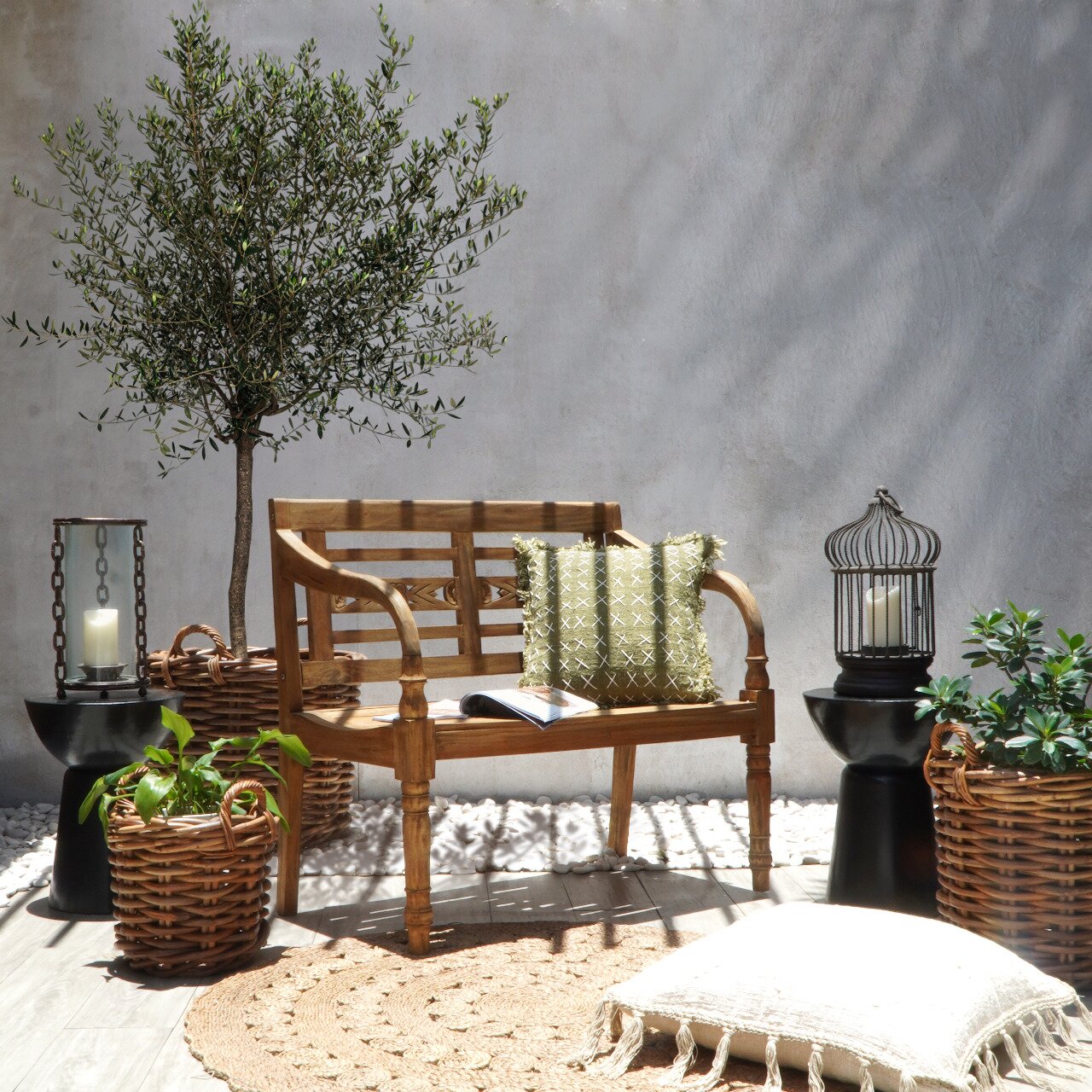 Holzgartenbank für zwei Personen in einem stilvollen Außenbereich, umgeben von Pflanzen und Dekorationen, seitliche Perspektive