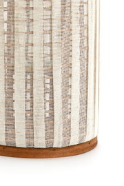 Nahaufnahme eines Windlichts mit einem gestreiften, gewebten Stoffdesign und einem Holzsockel, seitliche Perspektive