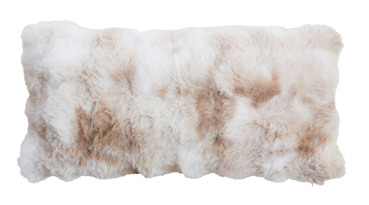 Weiches, flauschiges Kissen in Creme- und Beigetönen, aus der Vogelperspektive fotografiert.