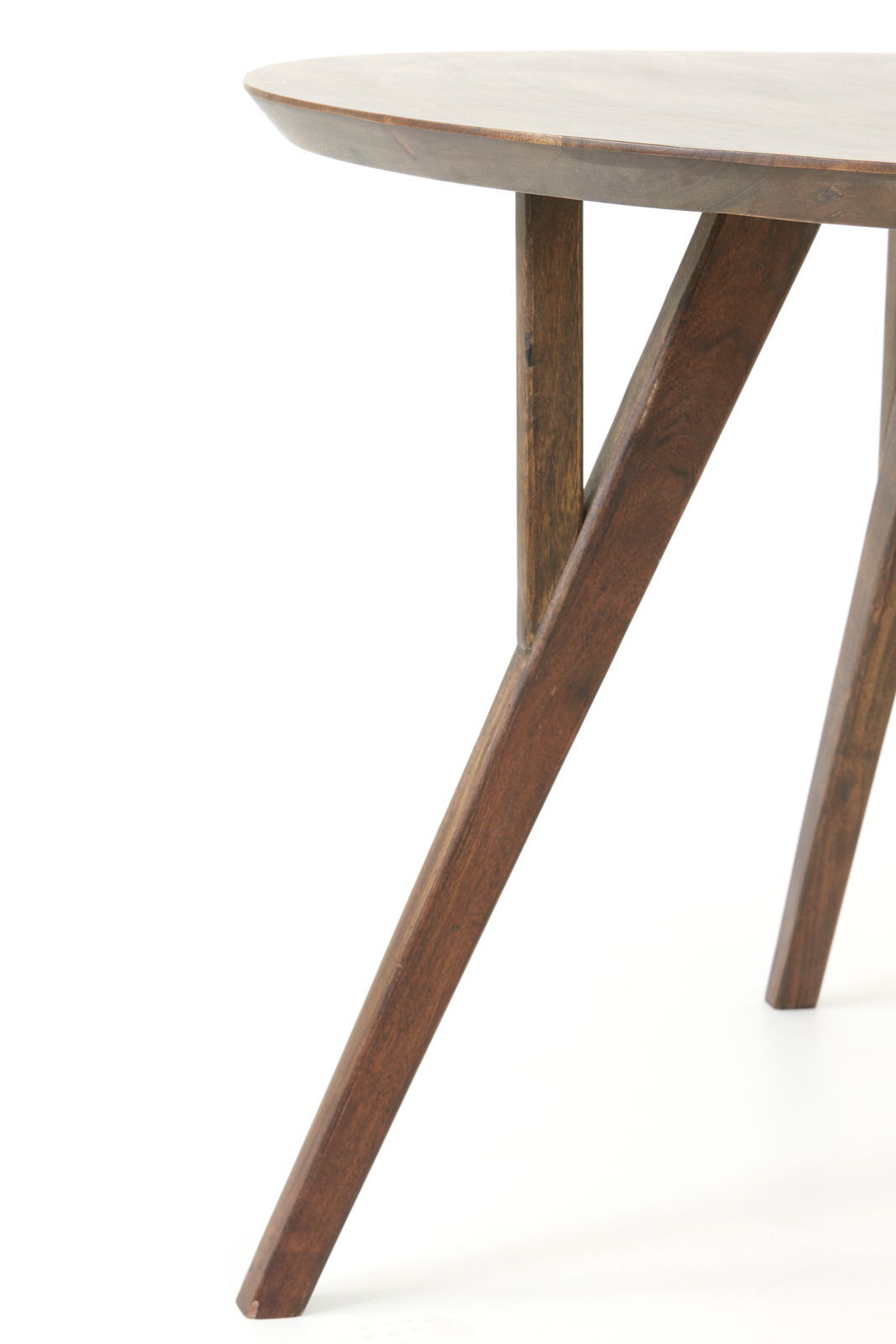 Nahaufnahme eines Esstisches mit runder Tischplatte und schrägen Holzbeinen, seitliche Perspektive.